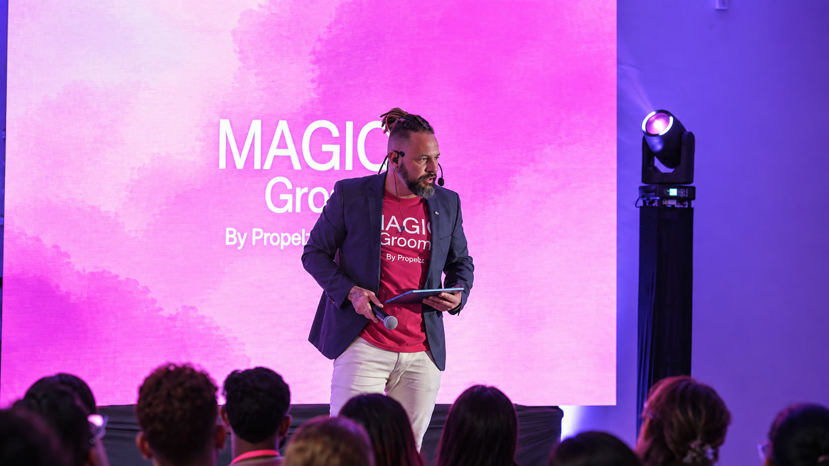 Marlon Vargas falando em evento, com a plateia diante do palco